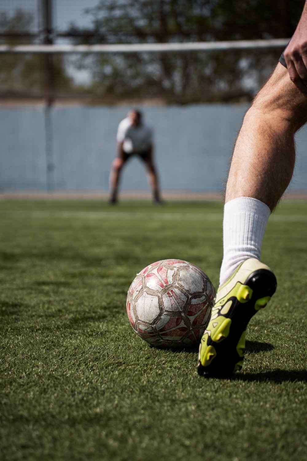 Joueur de football prêt à tirer un penalty, gardien en arrière-plan