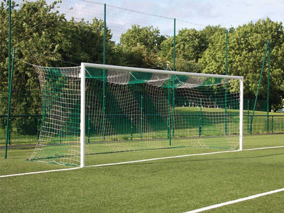 But de football extérieur avec filet vert sur terrain en herbe.